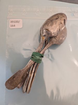 une cuillère en argent et un repose-cuillère posés sur un sac en plastique