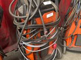 several welding equipment are stacked on top of each other in a garage