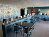 tables and chairs are lined up in a restaurant with a blue wall behind them