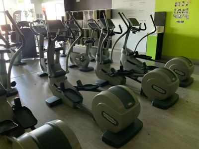de nombreux vélos d'appartement dans une salle de sport aux murs verts