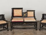 three chairs and a table in a room with a clock on the wall