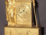 une horloge en or surmontée d'une statue