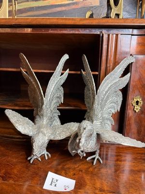 deux oiseaux en métal posés sur une table en bois
