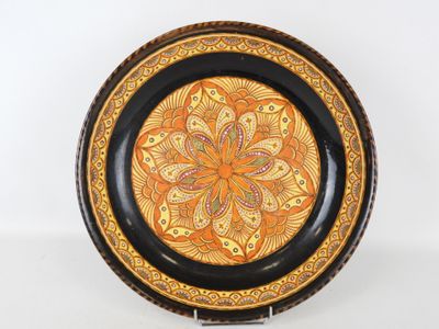 une assiette orange et noire ornée d'un motif décoratif