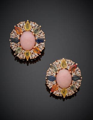 une paire de boucles d'oreilles en pierre rose et jaune posées sur un fond noir