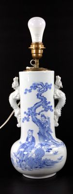a blue and white vase with a light on it