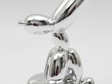 an image of a silver sculpture of a rabbit with a hat on it ' s head