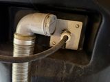 an image of a close up of a toilet with a hose attached to it