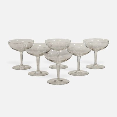six clear wine glasses sitting on top of each other on a white surface