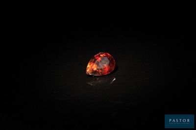 a red fire oplite stone on a black surface