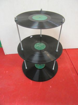 a three tiered display of vinyl records on a red floor
