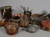 a pile of copper pots and pans on a table