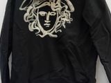 black hoodie with a gold medusant on the front