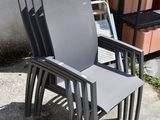 a stack of chairs sitting on a sidewalk next to a building