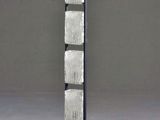 a tall metal and glass sculpture with a wooden base