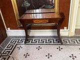 a small table with a mirror on it in the corner of a room