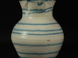a blue and white striped vase sitting on a table