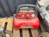 a red air compressor sitting on a pallet next to other tools