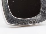 a close up of a silver ring with a black stone in it