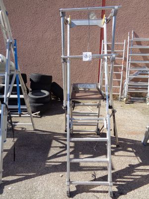 many ladders that are sitting outside on the ground