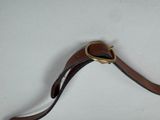 a brown leather strap with a gold buckle on it