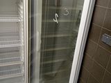 an open refrigerator in the corner of a bathroom