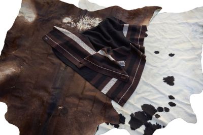 a brown and white cowhide rug with a black and white blanket