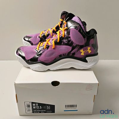 purple and black under armour basketball shoe on a white box