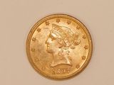 a close up of a gold coin on a white surface
