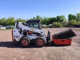 a picture of a small ski - loader parked in a parking lot