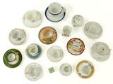 many cups and saucers arranged in a circle on the table