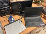 several laptops are sitting on a desk with a lot of wires