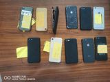 several cell phones are lined up on a table with sticky notes on them