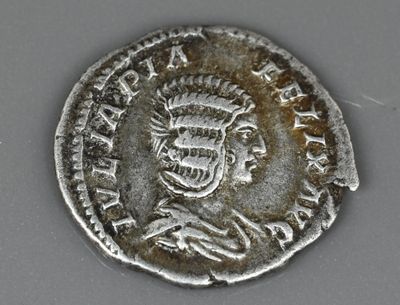 une vieille pièce d'argent ornée d'un crâne, posée sur une table