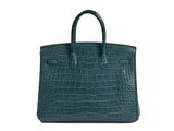 a green crocodile skin handbag on a white background