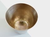 a silver bowl sitting on top of a white table