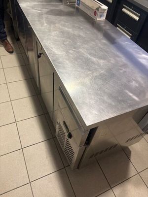 stainless steel counter top in a commercial kitchen with a person standing next to it