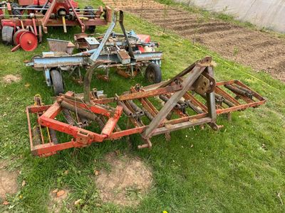 a tractor and a plow sitting in the grass