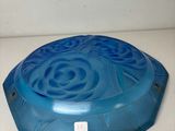a blue bowl on a white counter with a blue lid