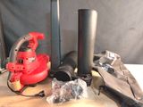 a red blower sitting on top of a table next to other items