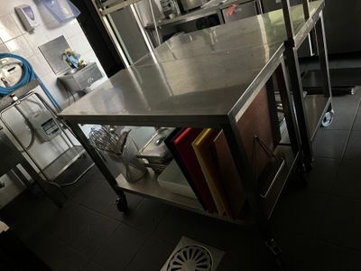 une cuisine avec un grand îlot en inox au milieu de la pièce