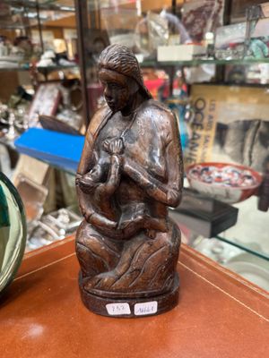 a statue of a woman holding a baby in a glass case