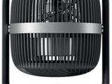 a black fan sitting on top of a table next to a white wall