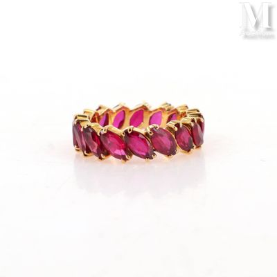 a close up of a gold ring with pink stones on a white surface