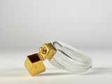 a close up of a glass bottle with a gold object inside of it