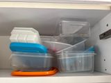 many containers that are sitting on a shelf in a cabinet