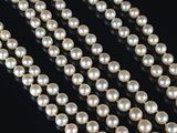 a close up of a strand of pearls on a black surface