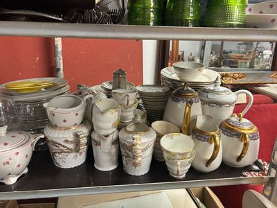 de nombreuses tasses et soucoupes posées sur une étagère dans une pièce