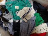 a white box filled with clothes and clothes on the floor