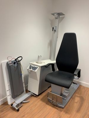 une photo d'une chambre d'hôpital avec une chaise et un écran